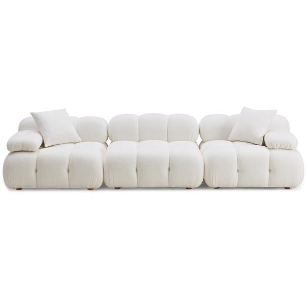 Sofa tapicerowana o subtelnym charakterze z dopracowana sylwetka w odcieniu bieli